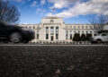 Vehicles pass in front of the Marriner S. Eccles Federal Reserve building in Washington, DC.