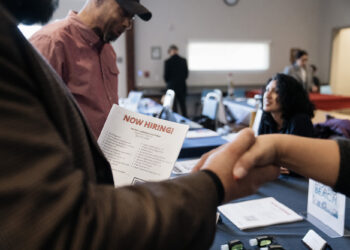 Attendees shake hands at an Employment and Resource Fair in Long Beach, California. Photographer: Eric Thayer/Bloomberg